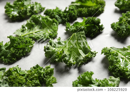 Raw cabbage leaves on parchment paper, closeup. Preparing kale chips 108225920