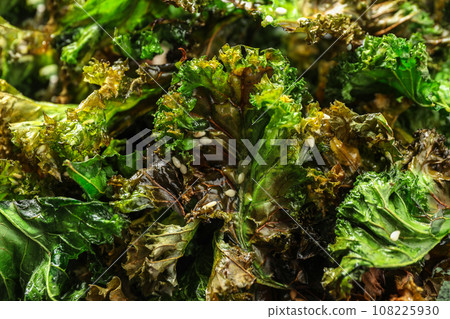 Tasty baked kale chips as background, closeup Tasty baked kale chips as background, closeup 108225930