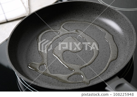 Frying pan with cooking oil on induction stove Frying pan with cooking oil on induction stove 108225948