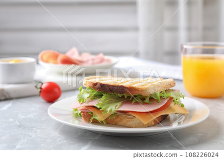 Tasty sandwich with ham on grey kitchen table. Space for text Tasty sandwich with ham on grey kitchen table. Space for text 108226024