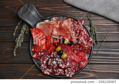 Tasty prosciutto and other delicacies served on wooden table, flat lay 108226065