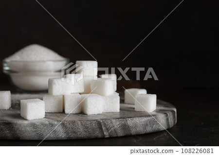 Heap of refined sugar cubes on black background Heap of refined sugar cubes on black background 108226081