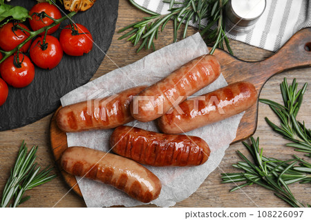 Tasty grilled sausages served on wooden table, flat lay 108226097