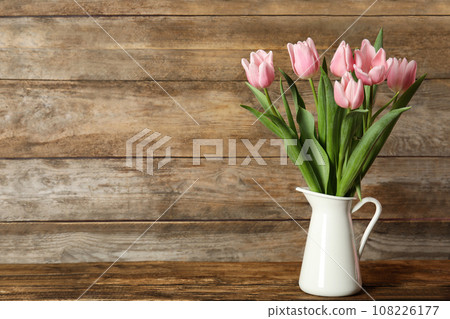 Beautiful pink spring tulips in vase on wooden table. Space for text 108226177