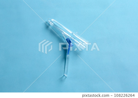 Anoscope on light blue background, top view. Hemorrhoid treatment 108226264