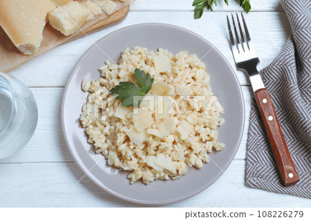 Delicious risotto with cheese on white wooden table, flat lay Delicious risotto with cheese on white wooden table, flat lay 108226279