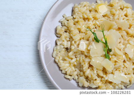Delicious risotto with cheese on white wooden table, top view Delicious risotto with cheese on white wooden table, top view 108226281