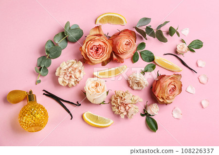 Beautiful flat lay composition with bottle of perfume, lemon and flowers on pink background 108226337