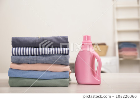 Stack of fresh laundry and detergent on white table in bathroom Stack of fresh laundry and detergent on white table in bathroom 108226366