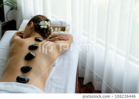 Hot stone massage at spa salon in luxury resort. Quiescent 108226446