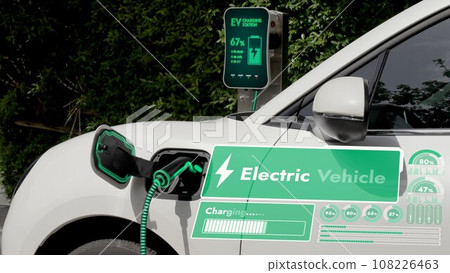 Electric car plug into EV charger display battery status hologram.Peruse Electric car plug into EV charger display battery status hologram.Peruse 108226463