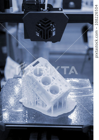 Prototype of car engine printed on 3D printer from molten white plastic on working surface 3D printer. Three-dimensional model. Additive progressive modeling technology. Modern new printing industry. Prototype of car engine printed on 3D printer from molten white plastic on working surface 3D printer. Three-dimensional model. Additive progressive modeling technology. Modern new printing industry. 108226504