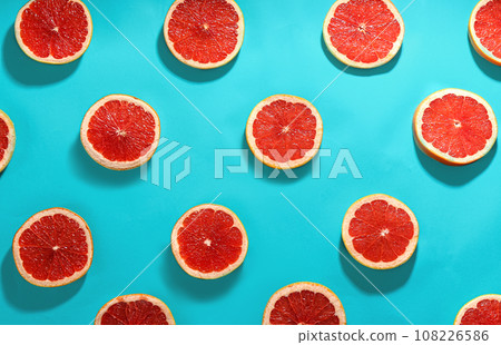 Tasty ripe grapefruit slices on blue background, flat lay 108226586