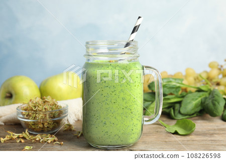 Tasty green buckwheat smoothie on wooden table 108226598