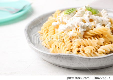 Tasty pasta with sauce and basil on white wooden table, closeup Tasty pasta with sauce and basil on white wooden table, closeup 108226623