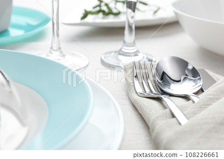 Elegant cutlery with green leaves on table, closeup. Festive setting 108226661