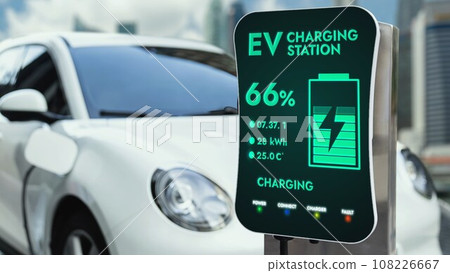 Electric car plugged in with charging station with city background. Peruse 108226667
