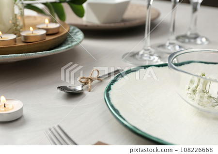 Elegant spoon tied with twine on white wooden table, closeup. Festive setting 108226668