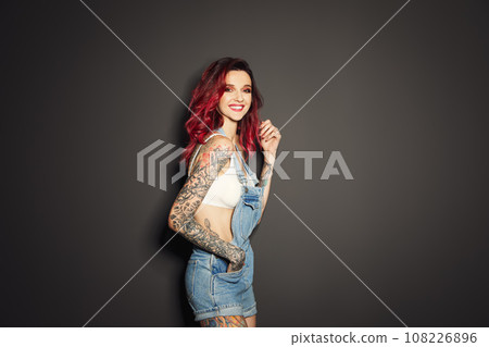 Beautiful woman with tattoos on body against black background Beautiful woman with tattoos on body against black background 108226896