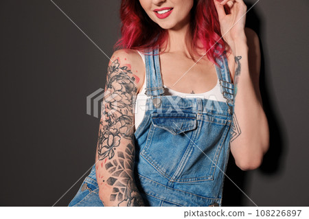 Beautiful woman with tattoos on body against black background, closeup Beautiful woman with tattoos on body against black background, closeup 108226897