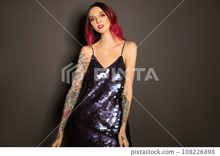 Beautiful woman with tattoos on arms against black background Beautiful woman with tattoos on arms against black background 108226898