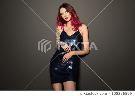 Beautiful woman with tattoos on body against black background Beautiful woman with tattoos on body against black background 108226899