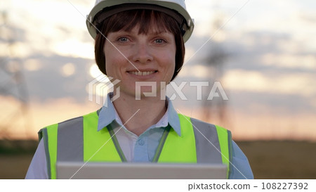 Positive engineer uses tablet conducting tests at power distribution station 108227392