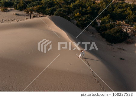 A happy family is traveling in Turkey. Vacation in Turkey, Patara. Tourists walk on the sand on the beach of Patara, Turkey. A traveling family. People on a sand dune. Vacation in Dubai. Copy space A happy family is traveling in Turkey. Vacation in Turkey, Patara. Tourists walk on the sand on the beach of Patara, Turkey. A traveling family. People on a sand dune. Vacation in Dubai. Copy space 108227558