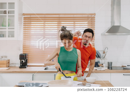 Husband feels worry behind his wife while she is cooking for him. 108228724