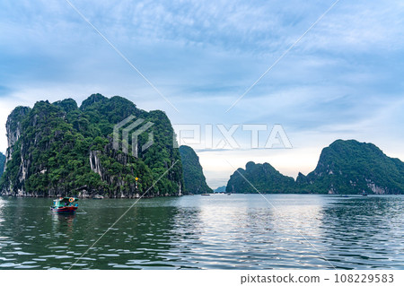 Strangely shaped rocks and fishing boats in Ha Long Bay, Vietnam Strangely shaped rocks and fishing boats in Ha Long Bay, Vietnam 108229583