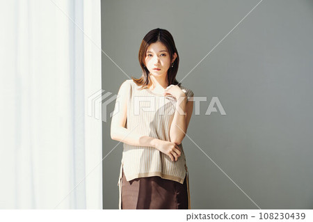 A woman standing by the window 108230439