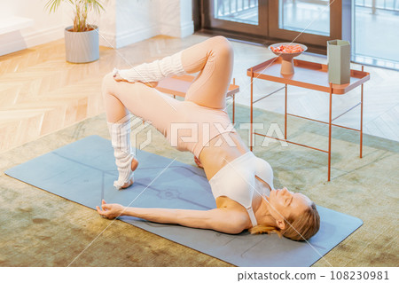 caucasian fitness woman practicing yoga at home 108230981