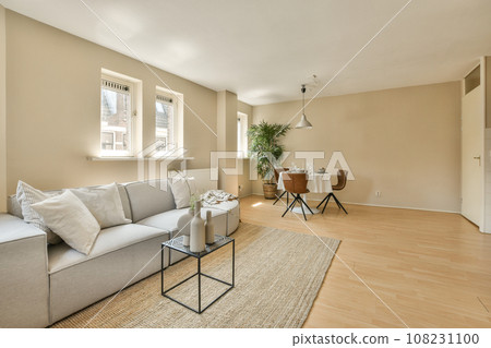 a living room with wood flooring and beige walls, white trim around the window sie is an area for furniture to be 108231100