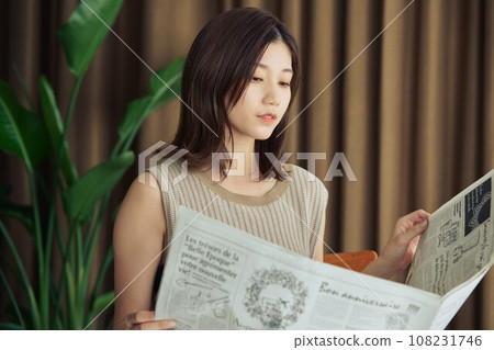 A woman reading a newspaper A woman reading a newspaper 108231746