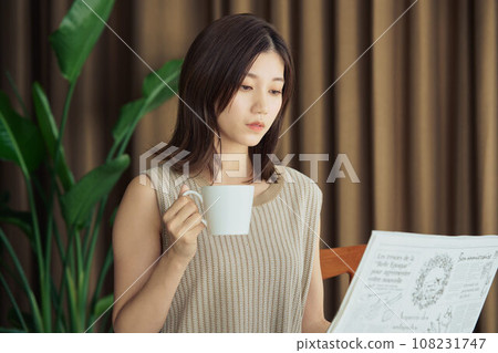 A woman reading a newspaper A woman reading a newspaper 108231747