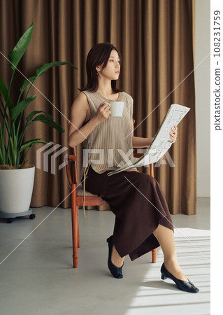 A woman reading a newspaper 108231759