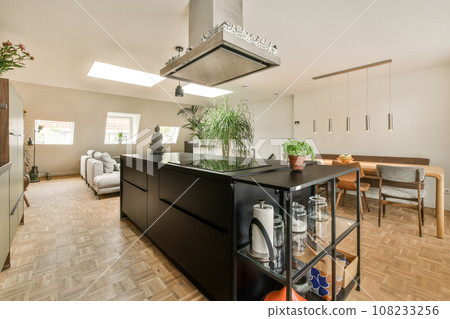a kitchen and dining area in a house with wood flooring, white walls, wooden floors and skylights 108233256