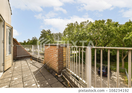 an outside area with a balcony and trees in the background, as seen from the top floor to the bottom 108234192