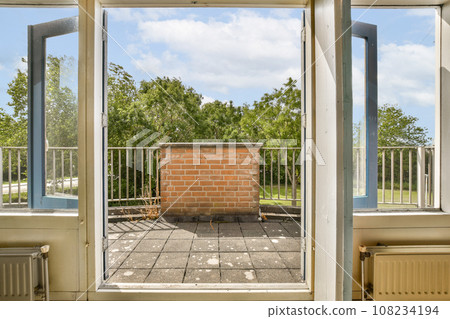 an open window with a brick wall in the middle and blue sky above it, as seen from inside outside an open window with a brick wall in the middle and blue sky above it, as seen from inside outside 108234194