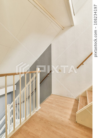 an empty room with wood flooring and white paint on the walls, there is a staircase leading up to the second floor an empty room with wood flooring and white paint on the walls, there is a staircase leading up to the second floor 108234197