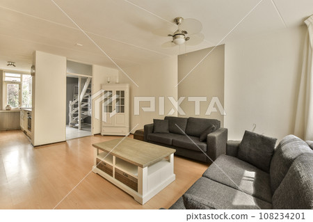 a living room with two couches and a coffee table in the center of the room is an open door a living room with two couches and a coffee table in the center of the room is an open door 108234201
