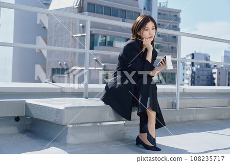 Business woman taking notes on the rooftop Business woman taking notes on the rooftop 108235717