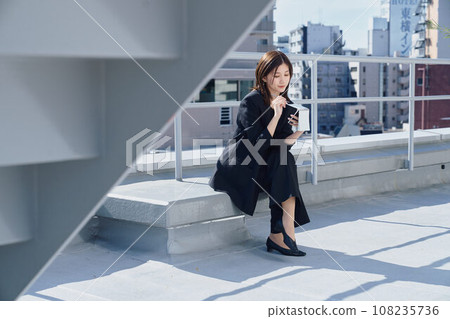 Business woman taking notes on the rooftop Business woman taking notes on the rooftop 108235736