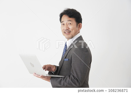Middle-aged businessman using a laptop White background Middle-aged businessman using a laptop White background 108236871