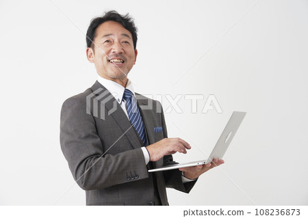 Middle-aged businessman using a laptop White background Middle-aged businessman using a laptop White background 108236873