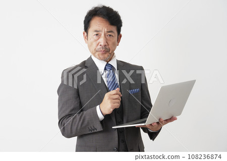 Middle-aged businessman using a laptop White background Middle-aged businessman using a laptop White background 108236874
