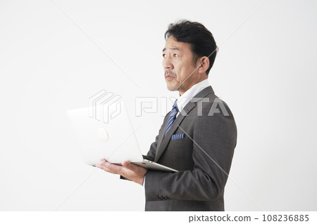 Middle-aged businessman using a laptop, white background 108236885