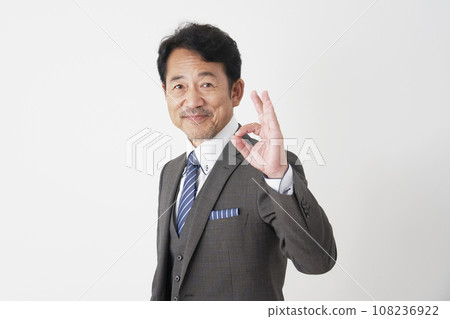 Middle-aged businessman giving OK sign, white background Middle-aged businessman giving OK sign, white background 108236922