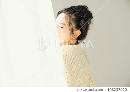 Portrait of a woman in white knitwear 108237010