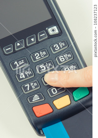 Payment terminal and finger entering PIN code. Credit card reader using for cashless paying 108237123